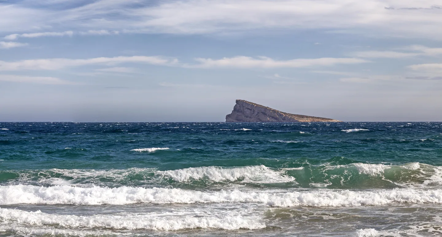 Benidorm Island seen from the coast, with Mediterranean waves in the foreground